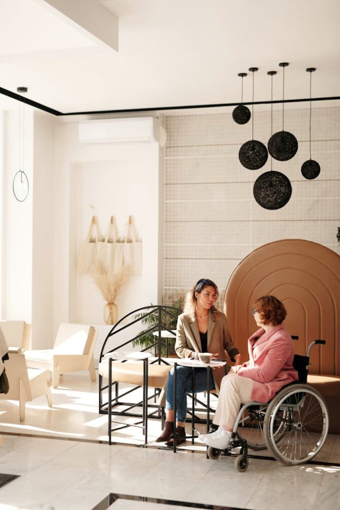 woman-meeting-with-client-4063918 A business meeting between two women, one in a wheelchair, in a stylish modern room.